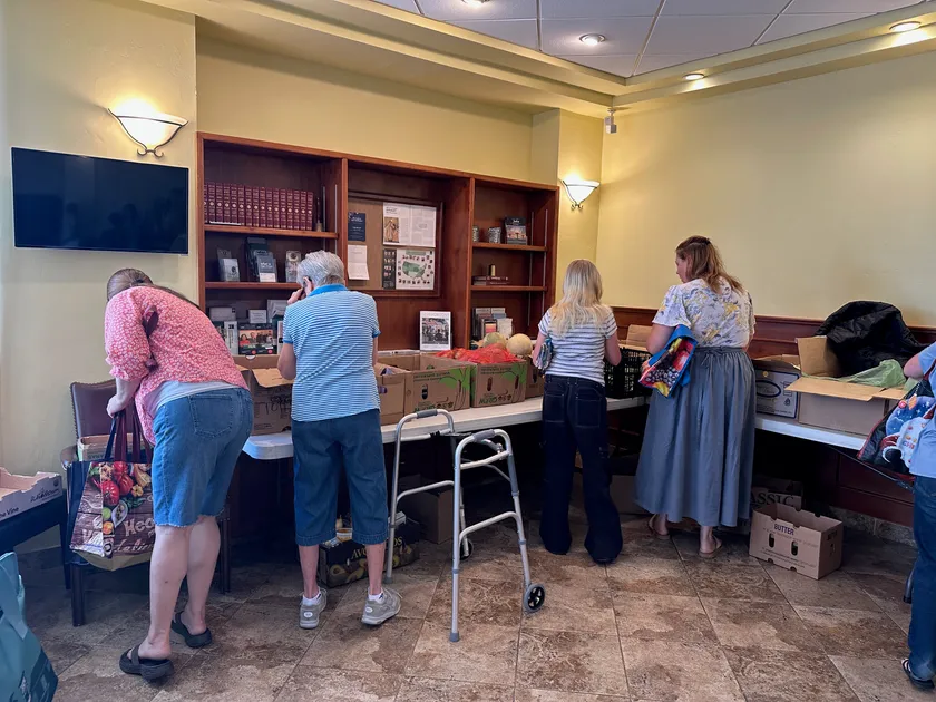 Neighbors choosing fresh produce and groceries at a GNCB food distribution